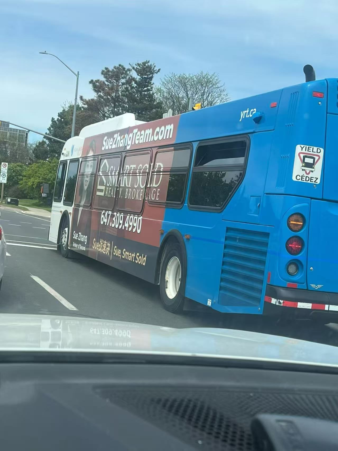 Sue Zhang and Smart Sold Realty advertising on the side of a York Region Transit bus on the road.